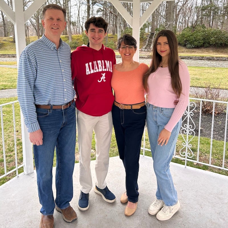 BMC Brighton cardiology patient Danielle Kinney standing with her husband Steven and their two children on their front porch